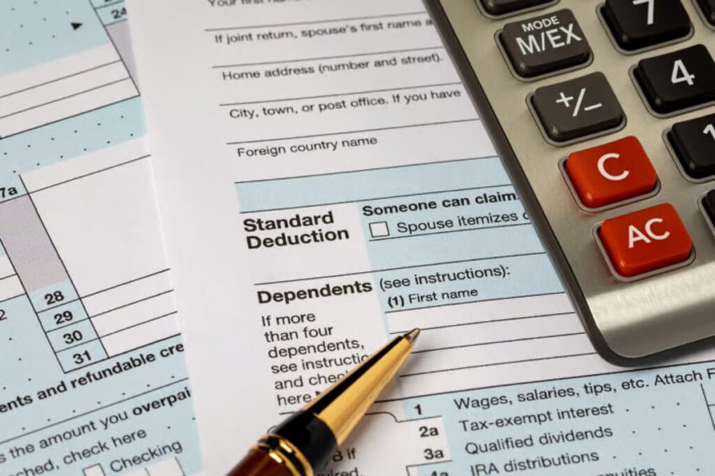 Calculator and tax documents on a desk, symbolizing last-minute tax preparations for the 2025 IRS filing deadline.